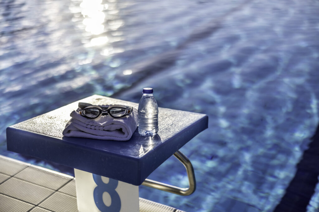 Swimming goggles and a towel placed on the starting bridge by the swimming pool | GLAAD Swimming goggles and a towel placed on the starting bridge by the swimming pool.