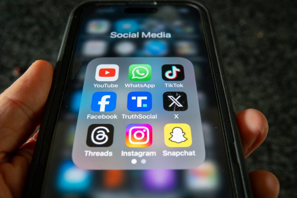 Phone with social media icons on display | GLAAD Phone with social media icons on display