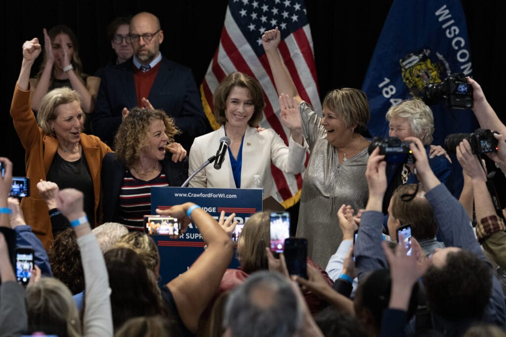 Dane County Circuit Court Judge Susan Crawford, flanked by Wisconsin Supreme Court justices, accepts victory in her race for Wisconsin Supreme Court justice on April 01, 2025 in Madison, Wisconsin. The former prosecutor ran against Judge Brad Schimel, who was endorsed by President Donald Trump and financially supported by billionaire businessman Elon Musk.